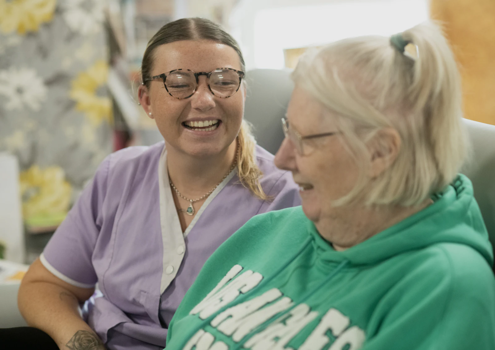 A carer sharing a laugh with an older woman at home